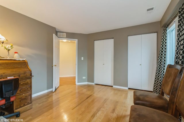 interior space with light wood-type flooring, baseboards, and visible vents