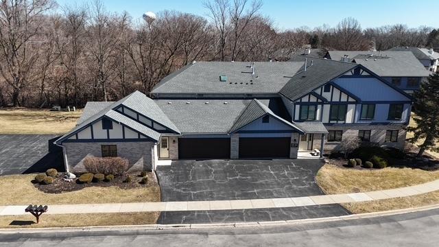 tudor-style house with driveway and an attached garage