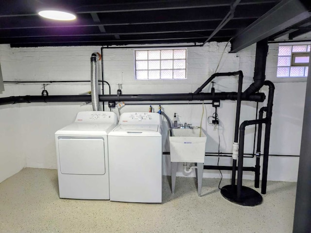 laundry area featuring washing machine and dryer, laundry area, a healthy amount of sunlight, and a sink