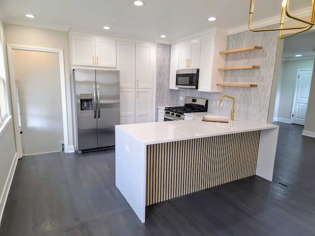 kitchen featuring white cabinets, appliances with stainless steel finishes, a peninsula, open shelves, and a sink