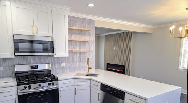 kitchen with stainless steel appliances, a peninsula, a sink, light countertops, and ornamental molding