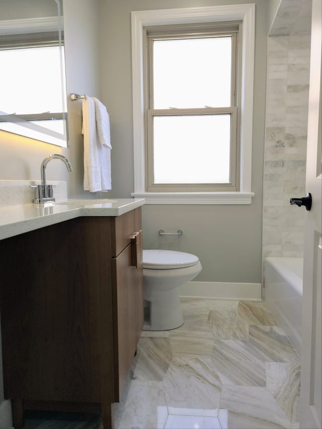 bathroom with marble finish floor, vanity, toilet, and baseboards