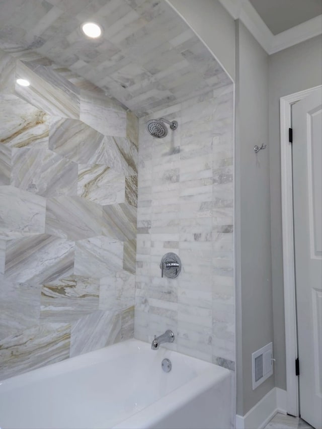 bathroom with ornamental molding, bathtub / shower combination, visible vents, and baseboards