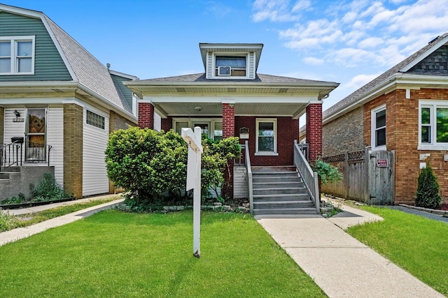 view of front of property featuring covered porch, brick siding, and a front lawn