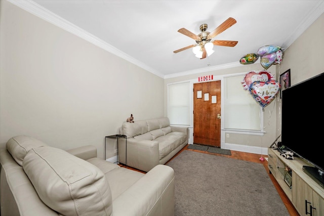 living room featuring ornamental molding, ceiling fan, baseboards, and wood finished floors