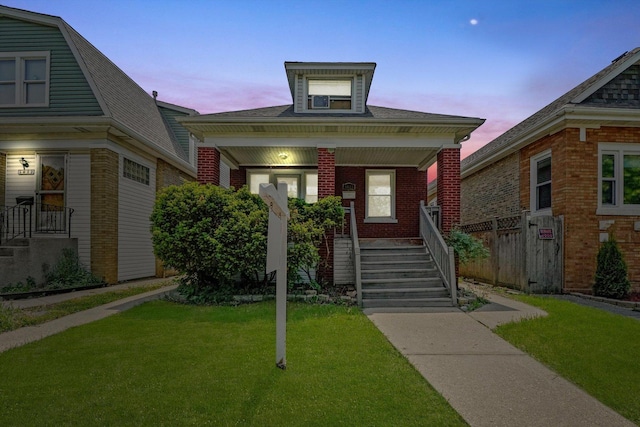 view of front of property with a porch, brick siding, and a lawn