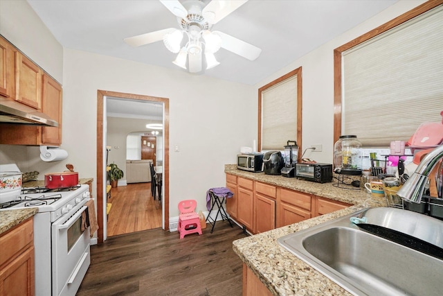 kitchen with white gas range oven, ceiling fan, stainless steel microwave, dark wood-type flooring, and a sink