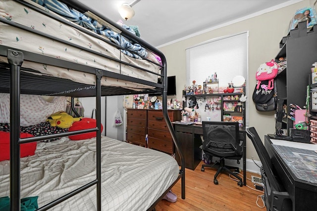 bedroom with crown molding and wood finished floors