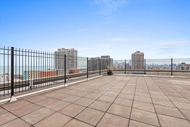 view of patio / terrace with a view of city and fence