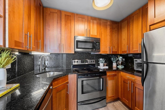 kitchen featuring brown cabinetry, stainless steel appliances, and a sink