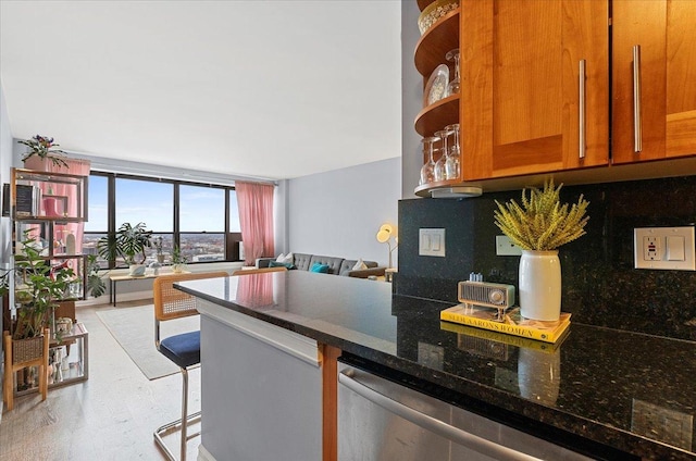 kitchen with decorative backsplash, dishwasher, brown cabinets, dark stone countertops, and open floor plan