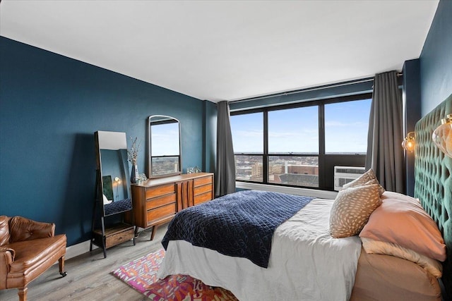 bedroom with light wood-type flooring and cooling unit