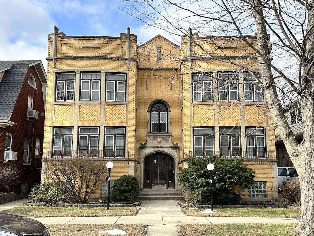 view of front facade with brick siding and cooling unit