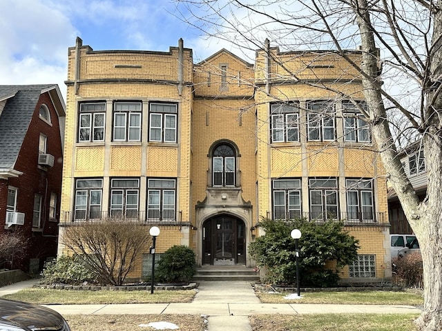 view of front facade with brick siding and cooling unit