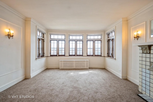 spare room featuring carpet floors, radiator, crown molding, and baseboards