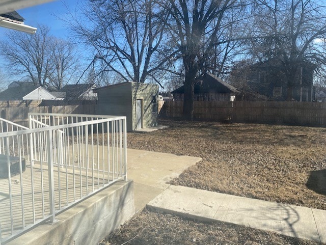 view of yard featuring a fenced backyard, a shed, and an outbuilding