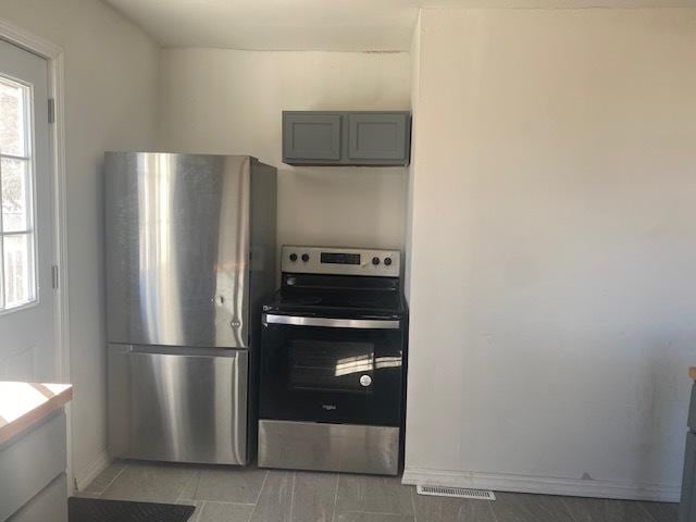 kitchen featuring baseboards, stainless steel appliances, and a wealth of natural light