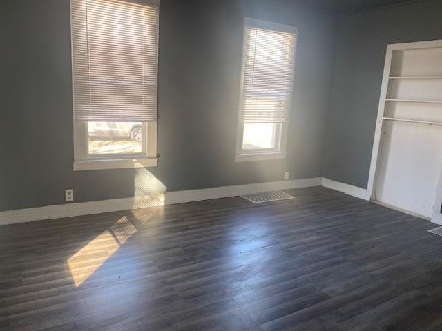 interior space with dark wood-type flooring and baseboards