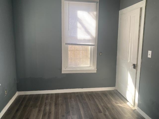 empty room with dark wood-style floors and baseboards