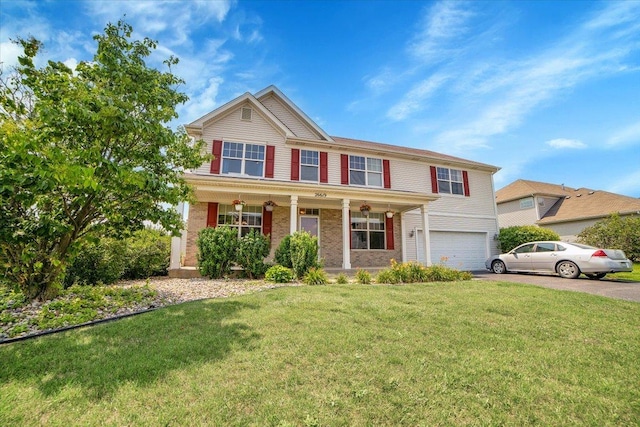 traditional home with covered porch, aphalt driveway, an attached garage, and a front yard