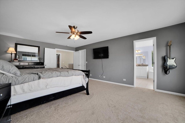 bedroom with ceiling fan, baseboards, connected bathroom, and light colored carpet