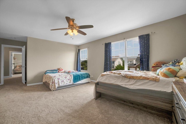 carpeted bedroom with baseboards and a ceiling fan