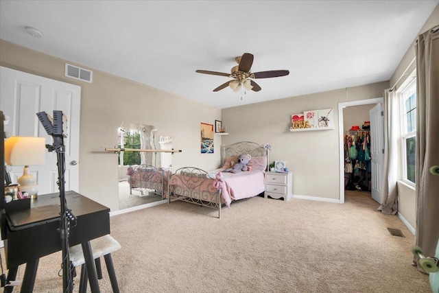 bedroom featuring carpet, visible vents, a walk in closet, and baseboards