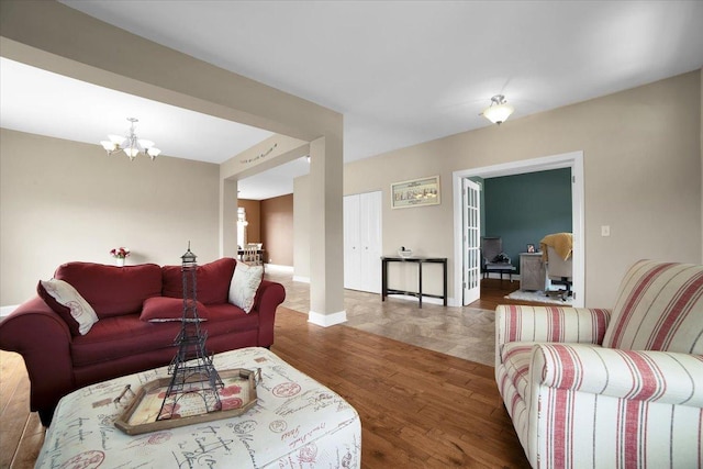 living room with a notable chandelier, baseboards, and wood finished floors