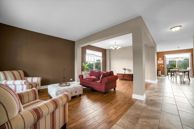 living area featuring a chandelier, light wood-type flooring, a wealth of natural light, and baseboards