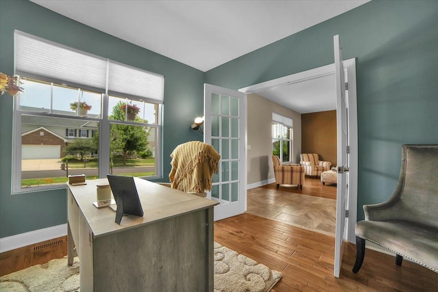 office space with french doors, wood finished floors, visible vents, and baseboards