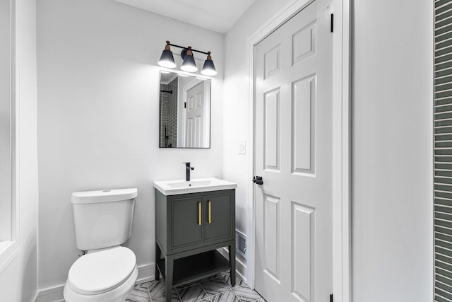 bathroom featuring vanity, toilet, and baseboards