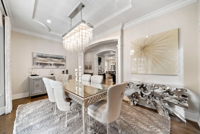 dining room with arched walkways, dark wood-type flooring, an inviting chandelier, decorative columns, and crown molding