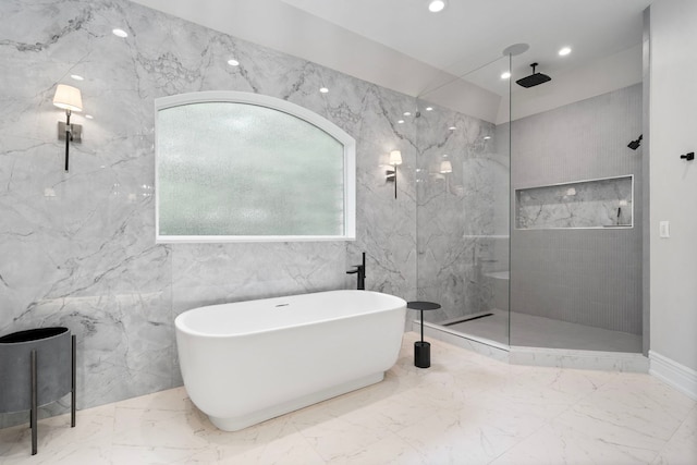 bathroom featuring marble finish floor, recessed lighting, a marble finish shower, and a soaking tub