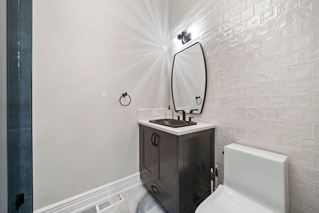 bathroom featuring toilet, baseboards, visible vents, and vanity