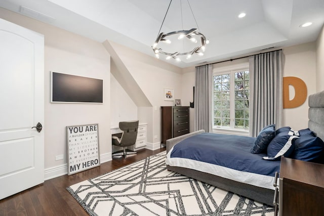 bedroom featuring recessed lighting, wood finished floors, visible vents, baseboards, and a tray ceiling