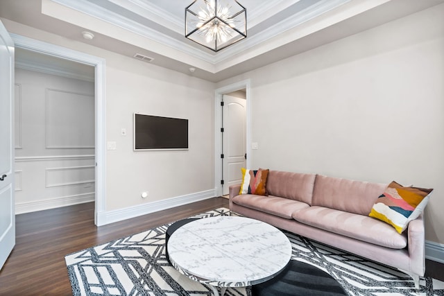 living area featuring dark wood-style floors, a tray ceiling, crown molding, visible vents, and an inviting chandelier