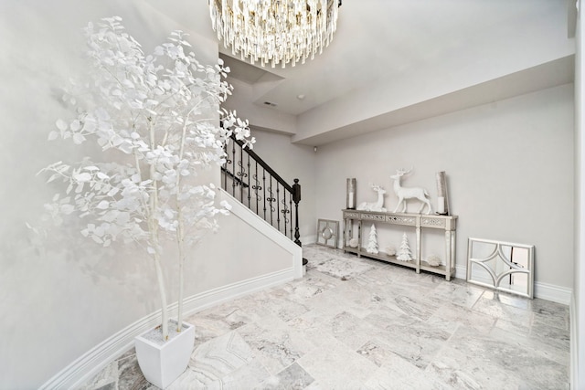 interior space featuring marble finish floor, baseboards, and an inviting chandelier