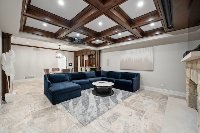 living area with baseboards, coffered ceiling, and a stone fireplace