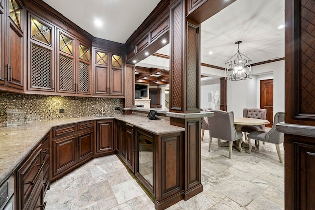 kitchen with stone tile floors, tasteful backsplash, glass insert cabinets, ornamental molding, and light stone counters