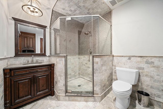 bathroom featuring visible vents, wainscoting, vanity, and tile walls