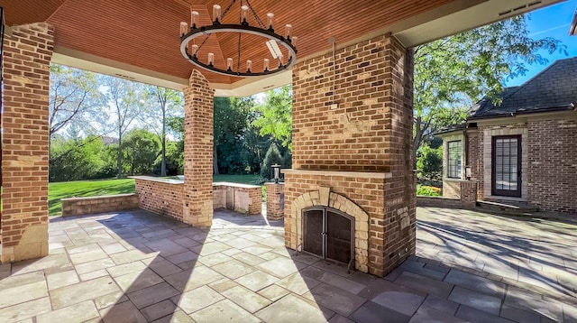 view of patio featuring an outdoor brick fireplace and a ceiling fan