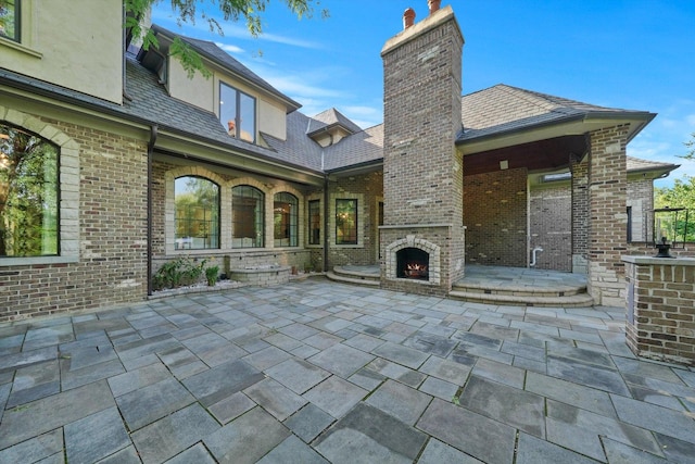 view of patio / terrace featuring an outdoor brick fireplace