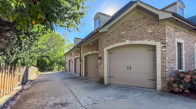 view of home's exterior with driveway, a garage, and brick siding