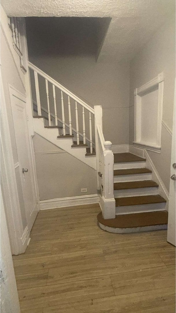 stairs featuring wood finished floors