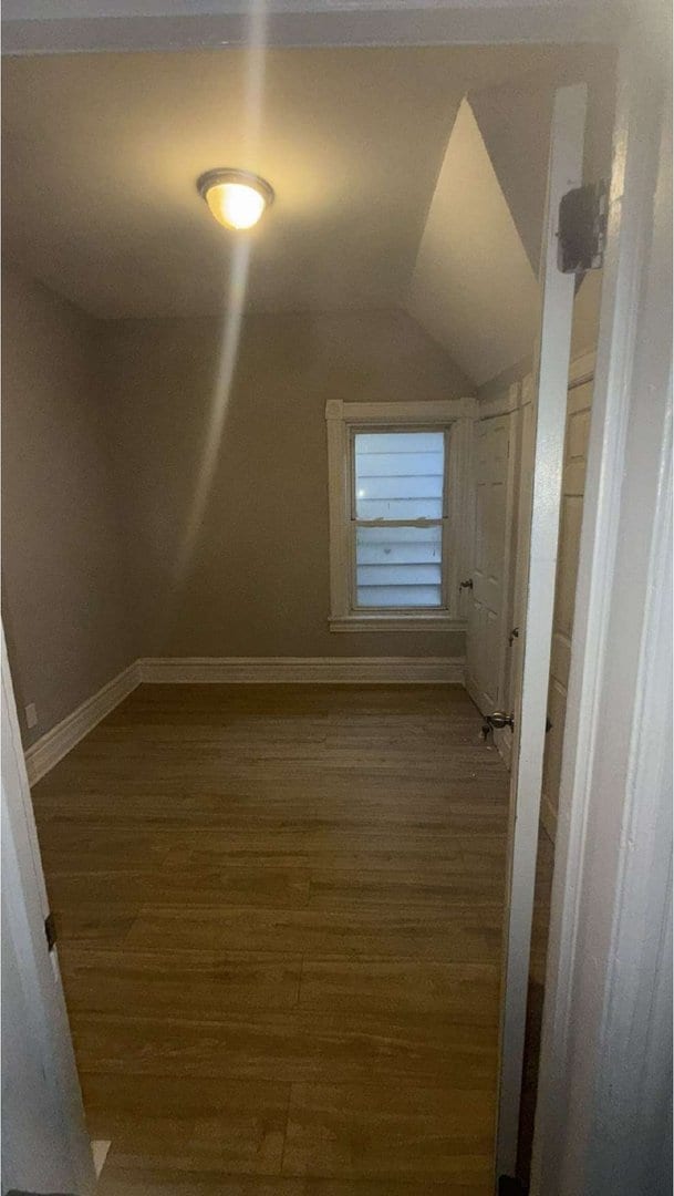 bonus room with lofted ceiling, wood finished floors, and baseboards