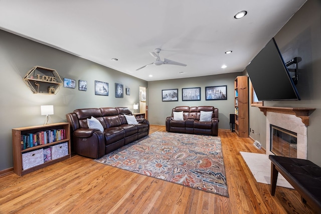 living area with recessed lighting, a fireplace with flush hearth, ceiling fan, wood finished floors, and baseboards