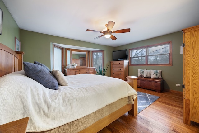 bedroom with ceiling fan, baseboards, and wood finished floors