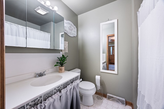 full bathroom with toilet, baseboards, visible vents, and vanity