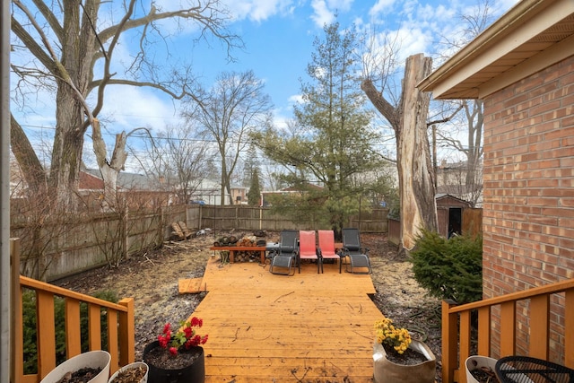 view of yard featuring an outbuilding, a fenced backyard, a deck, and a shed