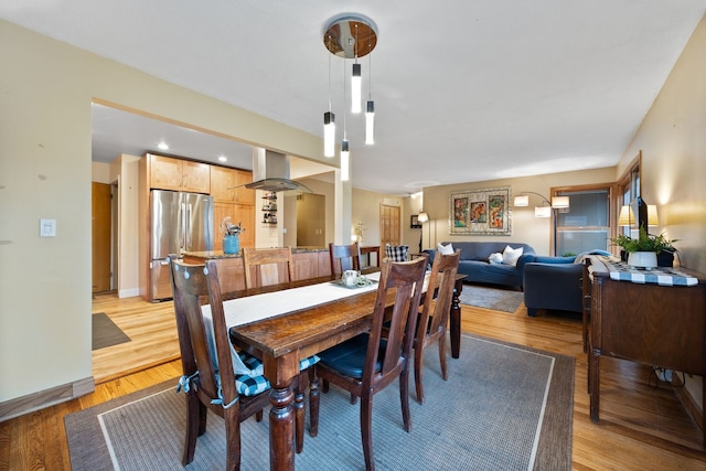 dining space with light wood-style flooring and baseboards